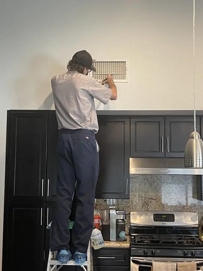 Technician inspecting an air vent during HVAC service in Coeymans